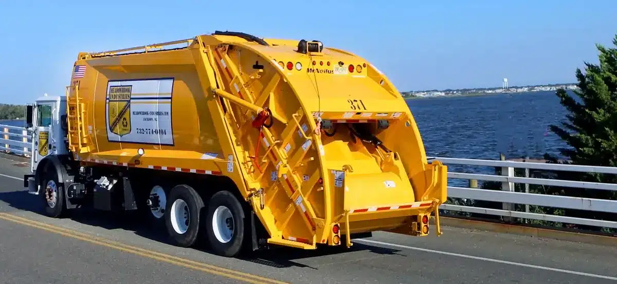 Yellow McNeilus EXTRA COMPACTION REAR LOADER
